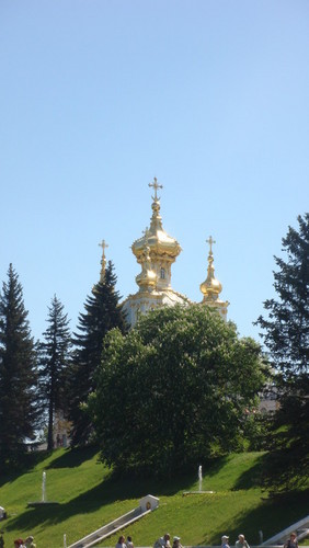 Виднеется церковь за кроной деревьев...